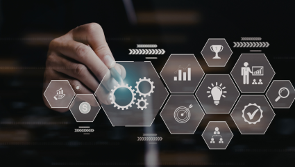 En hand pekar på digitala ikoner i hexagoner som symboliserar bland annat kugghjul, tillväxt, idéer och målsättning. Käsi osoittaa digitaalisia heksagonimuotoisia ikoneja, jotka kuvaavat muun muassa rattaita, kasvua, ideoita ja tavoitteita.