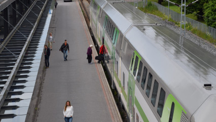 Människor kliver på ett tåg. Ihmisiä nousee junan kyytiin.