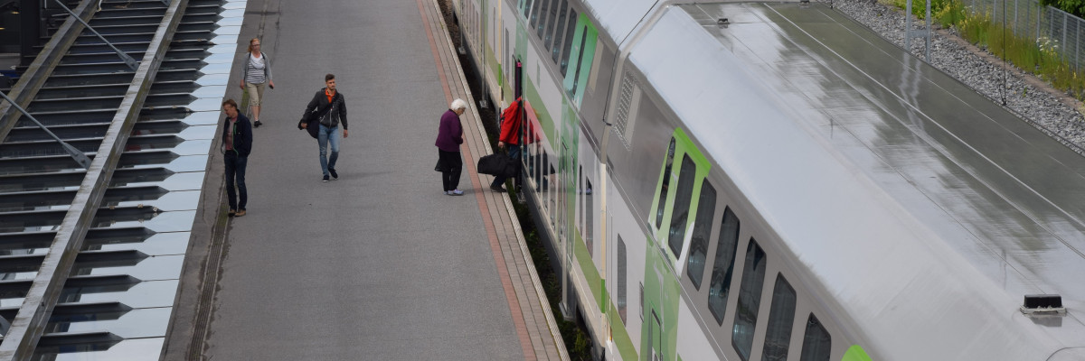 Människor kliver på ett tåg. Ihmisiä nousee junan kyytiin.